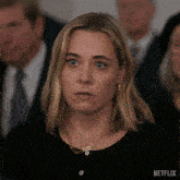 a woman sitting in a crowd with a netflix logo on the bottom right