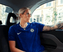 a woman wearing a blue shirt with a chelsea logo on it