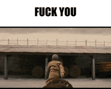 a sign that says " fuck you " on top of a fence