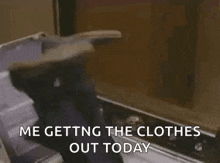 a person is getting clothes out of a washing machine and says `` me getting the clothes out today ''