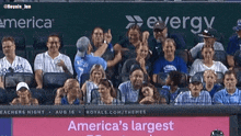 a group of people sitting in a stadium with a sign that says " america 's largest "