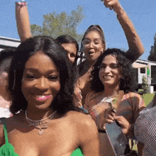 a group of women are posing for a picture and one woman is wearing a green top