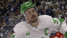 a hockey player wearing a white jersey with the letter c on the sleeve