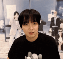 a young man wearing a black t-shirt with a k-pop bear on it