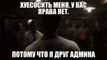a man in a white shirt is talking to another man in a dark room in a meme