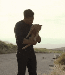 a man is holding a cat in his arms