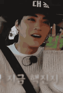 a close up of a person wearing a hat and a sweater in a car .
