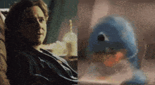 a man sitting on a couch next to a picture of a blue duck