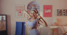 a woman in a room with a strong women club poster on the wall