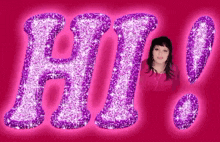 a woman in a pink shirt is standing in front of a purple hi sign