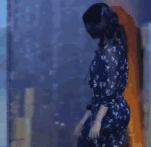 a woman is wearing a virtual reality headset while standing in front of a glass wall .