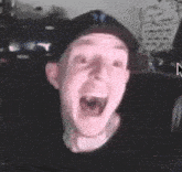 a man in a baseball cap is making a funny face .