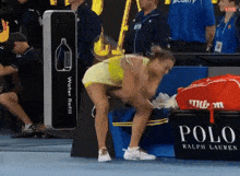 a woman squatting next to a sign that says polo
