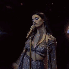 a woman singing into a microphone in a very revealing dress