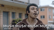 a man is standing in front of a building with his mouth open and says mush mush mush mush .