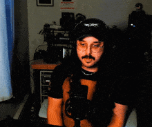 a man wearing headphones and a hat with the word x on it