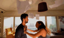 a man and a woman are fighting in a living room