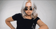 a woman wearing sunglasses and a black t-shirt that says " your " on it