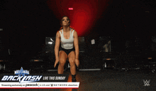 a woman is doing push ups in front of a sign that says backlash live this sunday
