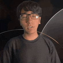 a young man wearing glasses and a jacob shirt