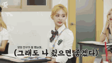 a girl in a school uniform is sitting at a desk with korean writing on it