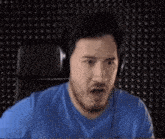 a man wearing headphones is making a funny face while sitting in a chair .