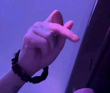 a close up of a person 's hand making a heart shape with their finger .