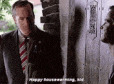 a man in a suit and tie is talking to another man in front of a wooden door .