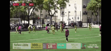 a soccer game is being played on a field with advertisements for telecable