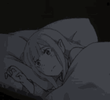 a girl is laying in bed with a pillow and blanket .