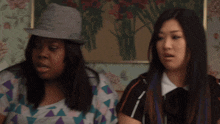 two women are sitting next to each other and one has purple hair