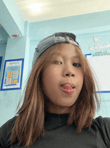 a girl sticking her tongue out in front of a sign that says ' a '