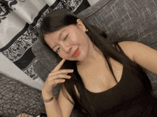 a woman laying on a couch with her eyes closed and her hand on her face