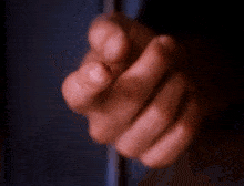 a close up of a person 's hand holding something in a dark room
