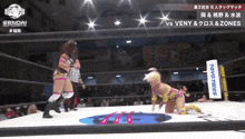 two women wrestling in a ring with a toyo tires sign