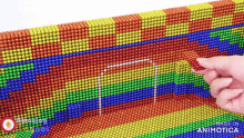 a person 's finger is pointing at a soccer goal made of magnets