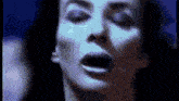 a close up of a woman 's face with her mouth open in the dark .
