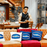 a man standing in a room with vaseline pillows on the couch