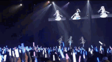 three anime girls are dancing on a stage