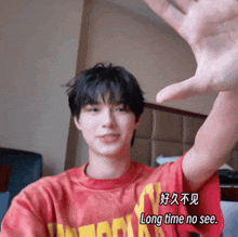 a person wearing a red shirt that says long time no see on it