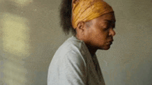a woman wearing a headband and a white shirt is sitting down .