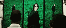 a woman is covering her mouth while holding a sword in front of a screen .