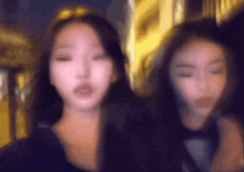 two women are standing next to each other with their eyes closed .