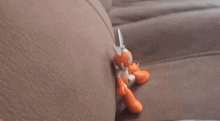 a person is holding a pair of scissors over a couch