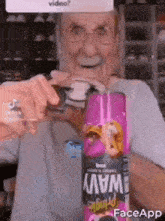 an older man is holding a can of pringles wavy chips .