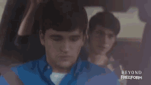 a man in a blue shirt is sitting in the back seat of a car with the words beyond freeform on the bottom right