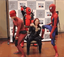 a woman in a chair is surrounded by a group of superheros