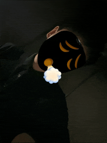 a person wearing a black mask with a yellow face on it