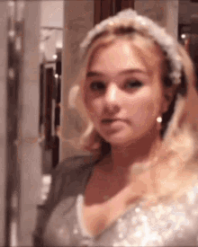 a woman wearing a headband and earrings looks at the camera .