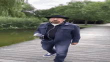 a man wearing headphones and a hat is walking across a wooden bridge